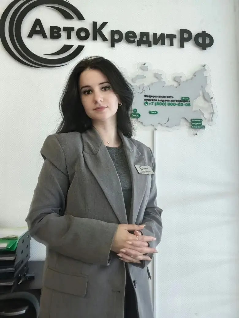 Кредитный специалист «АвтоКредитРФ» на рабочем месте под логотипом компании